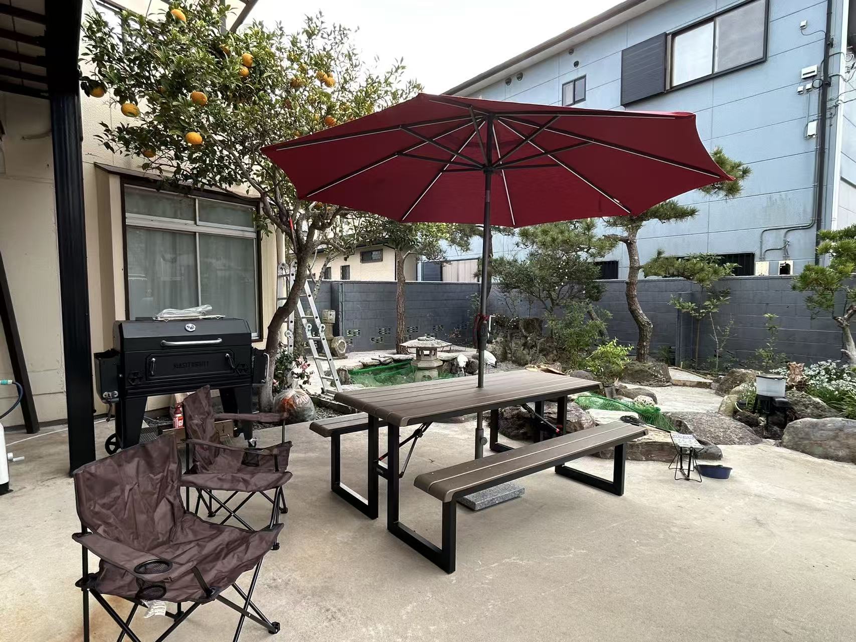 パラソルの下に置かれたBBQテーブルとグリル