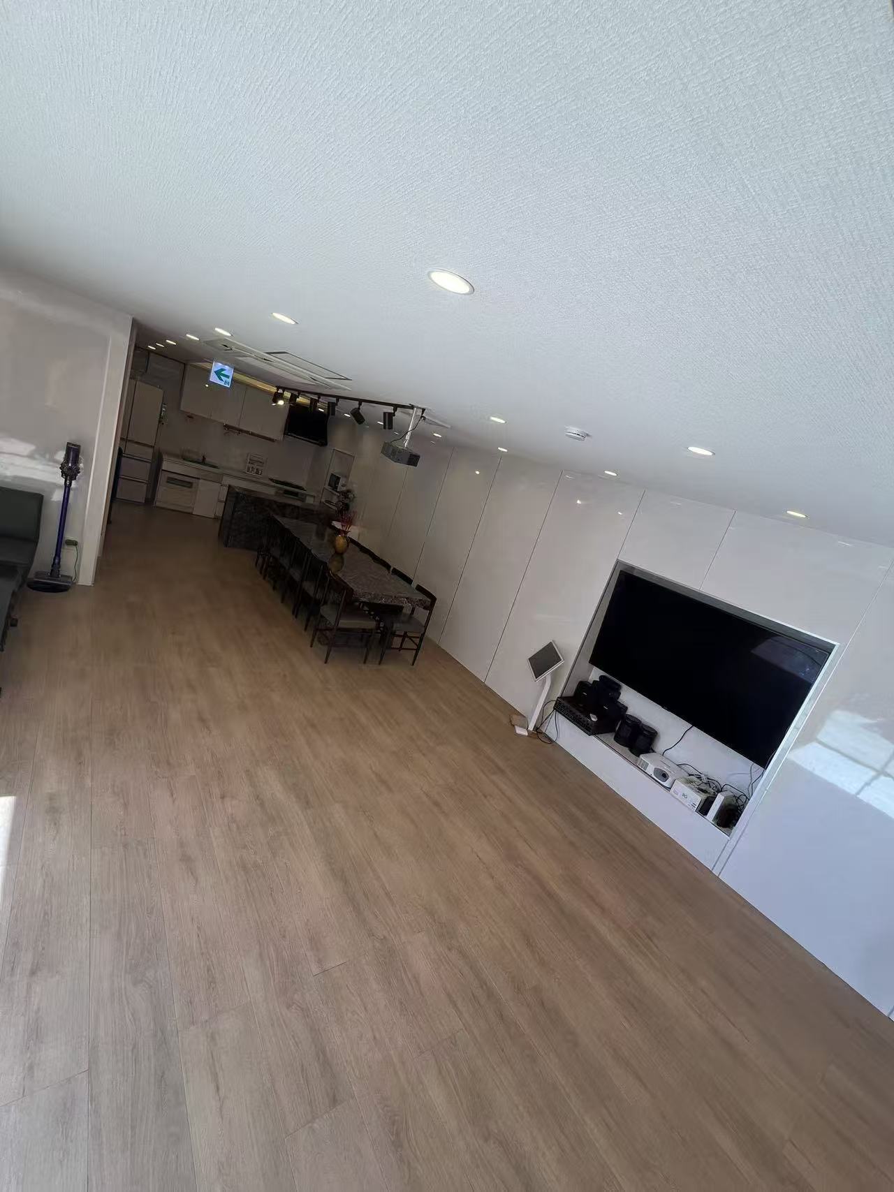 大型テレビとダイニングテーブルのある広間